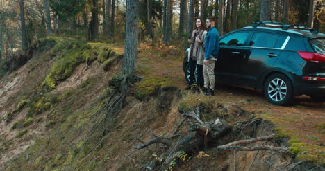 Couple-admire-view-of-forest-by-their-car-4K